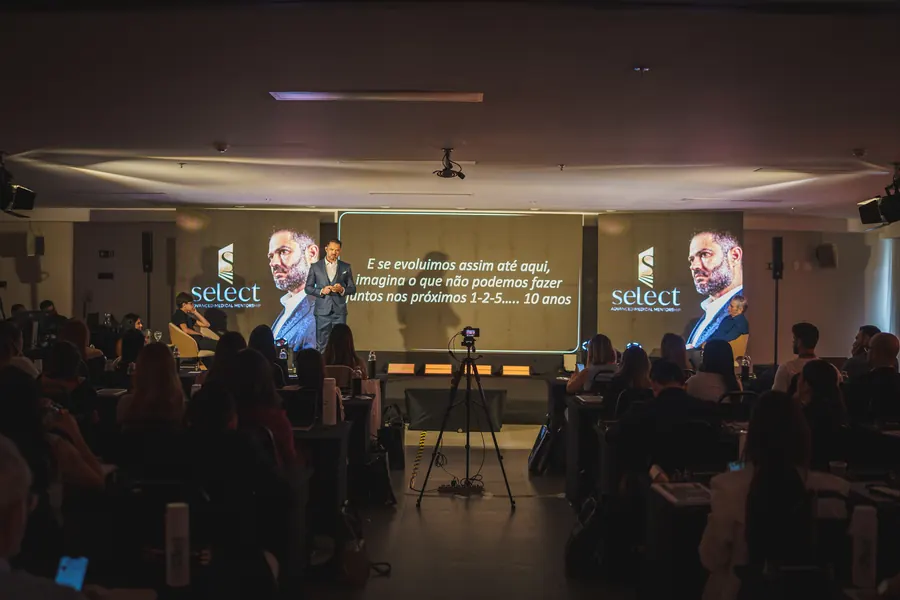 Dr. Dias Júnior no palco da 5ª Imersão Médica diante da plateia de médicos